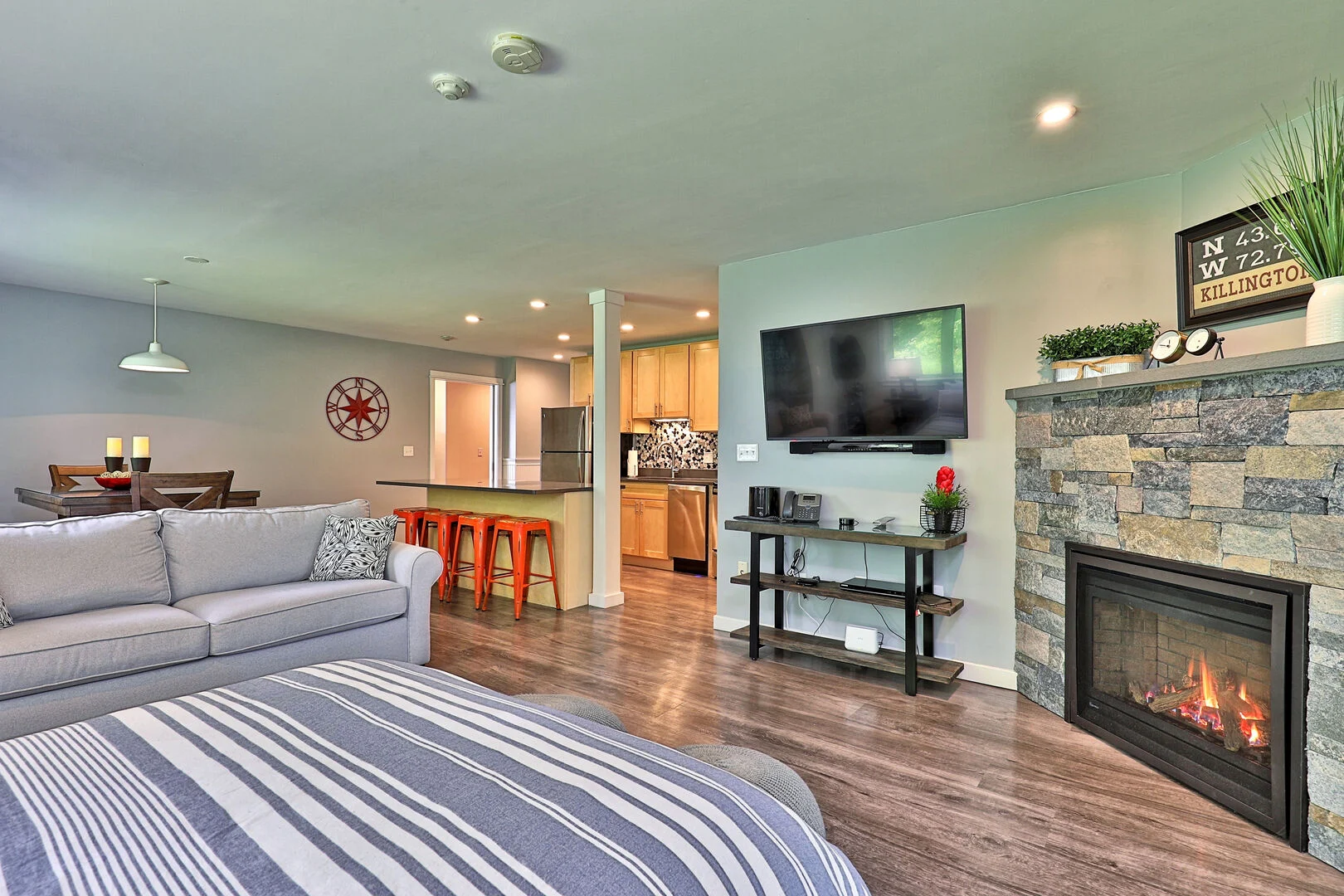 View of a condo room featuring a fireplace, TV and queen bed.